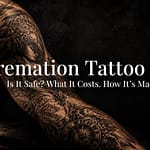 Elaborate black-and-grey memorial tattoo on a man's forearm lit in dramatic low light beside a glass bottle of cremation tattoo ink