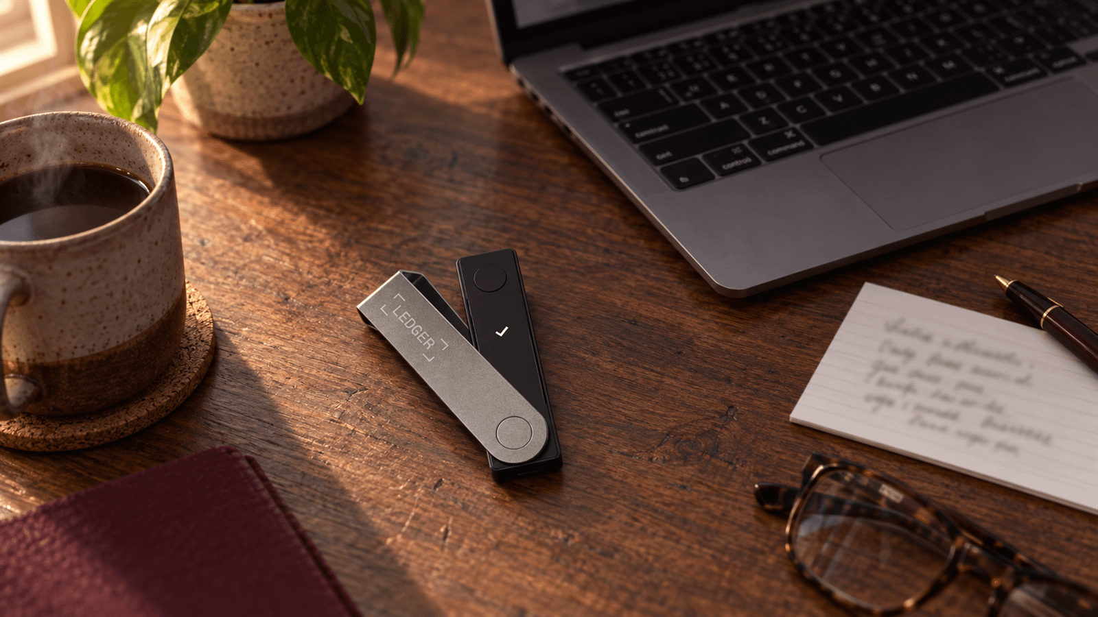 A Ledger Nano X hardware wallet on a home desk mid setup, the owner key in a two of three bitcoin inheritance vault