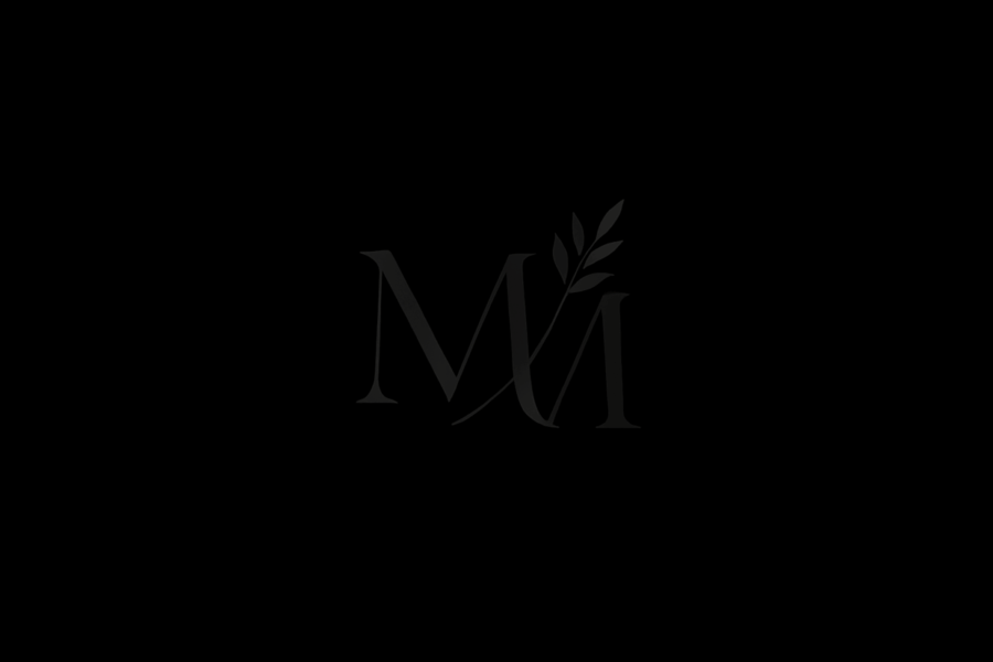 Subtle MM monogram logo on a black background representing Memorial Merits' legacy theme